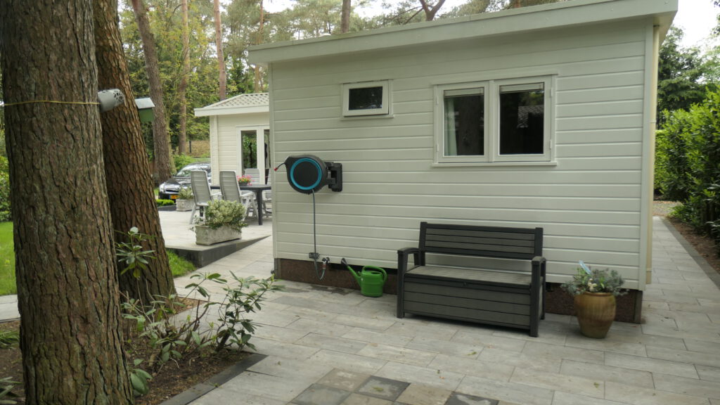 Foto achterkant chalet vanaf tweede terras/schaakbord/trampoline
